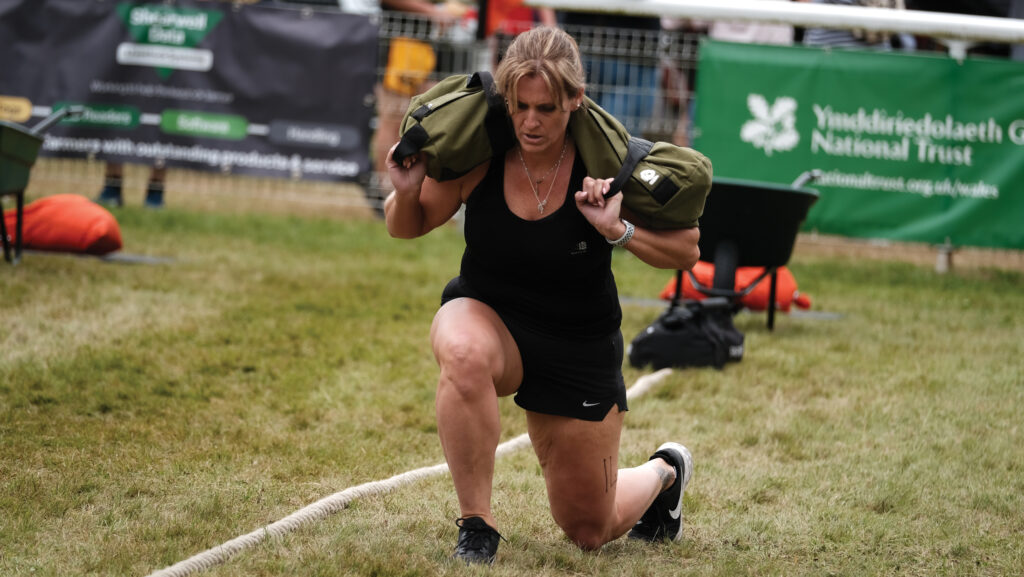 Amy Moore performing lunges while holding a weighted bag