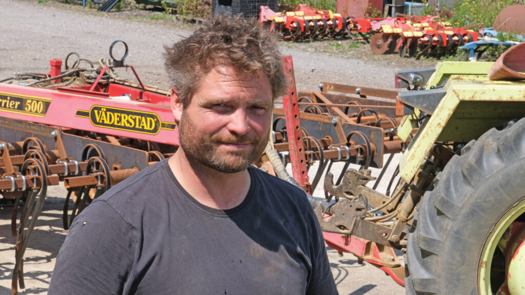 Andrew Metson standing amongst farming machinery