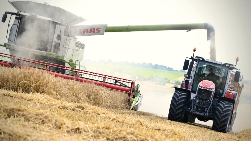 Tractor and combine harvester in a field