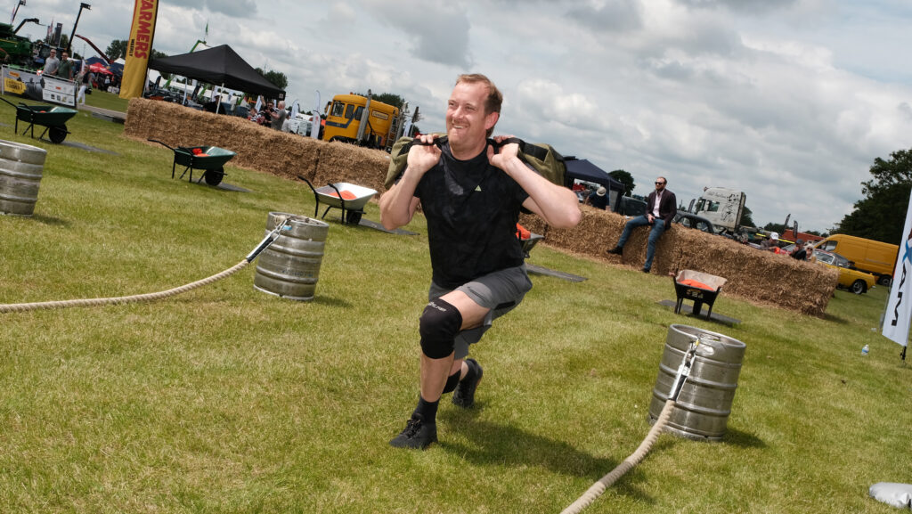 David Childerhouse performing lunges while holding weighted bag