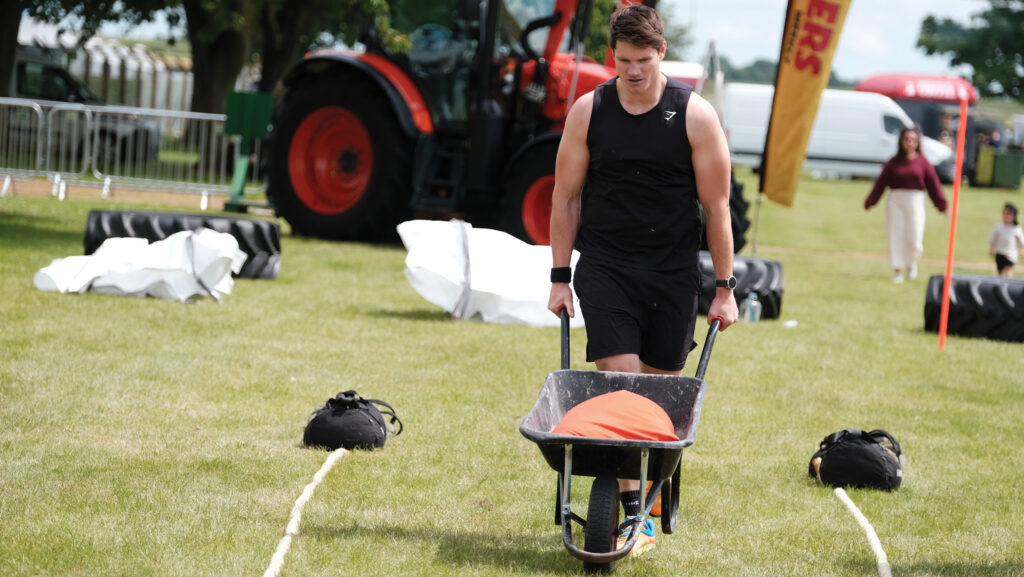 David Jones pushing a weighted wheelbarrow