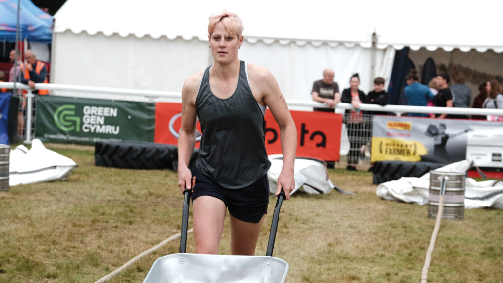 Emily Ashford pushing a weighted wheelbarrow