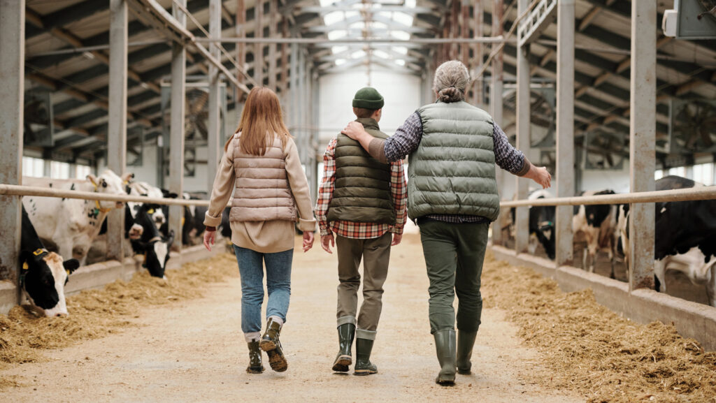 A man and two children in a cattle shed