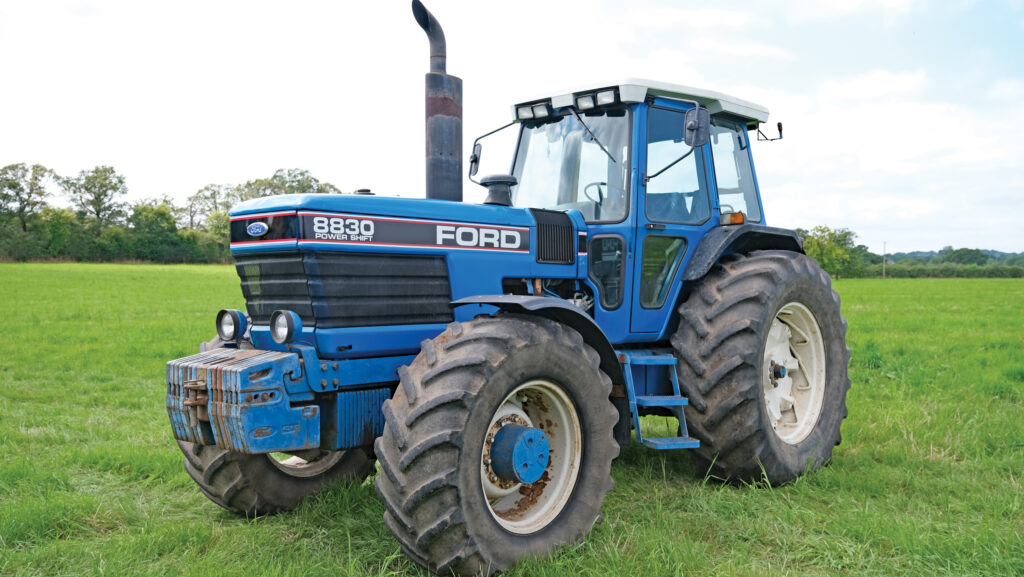 Older Ford 8830 tractor parked in a field