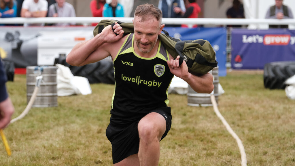 James Browne performing lunges while holding a weighted bag