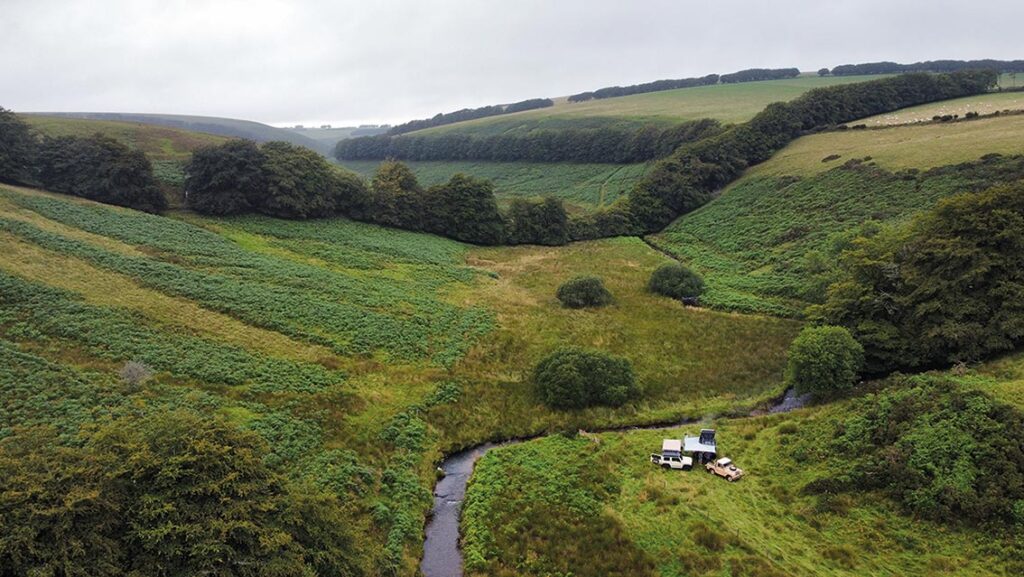 Campervan in fields with a river running through