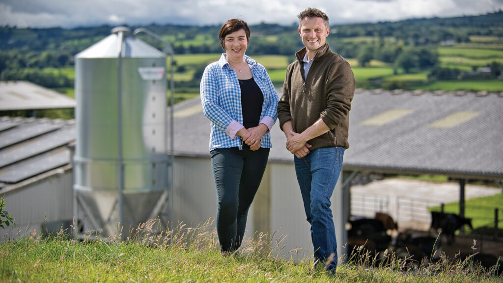 Rachel and Rheinallt Harries standing near a shed and feed silo