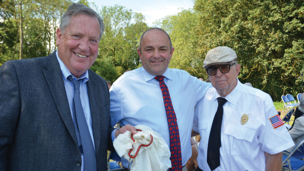 Stephen Honeywood with Patrick Hagerty and Frank McCluskey holding parachute remnant at a World War Two memorial service