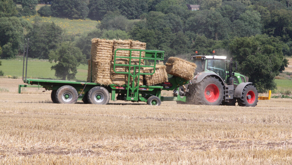 Tractors bringing in wheat straw