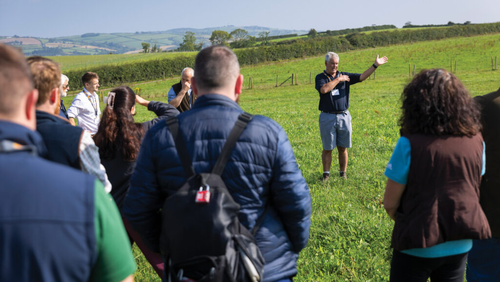 Dairy farmer showing visitors his farm