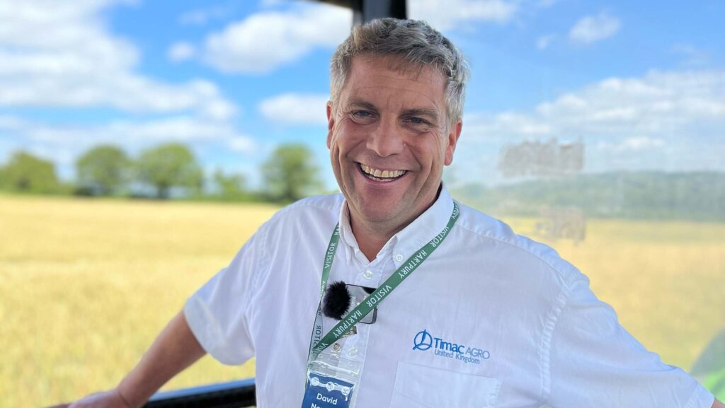 David Newton posing for the camera with crops behind