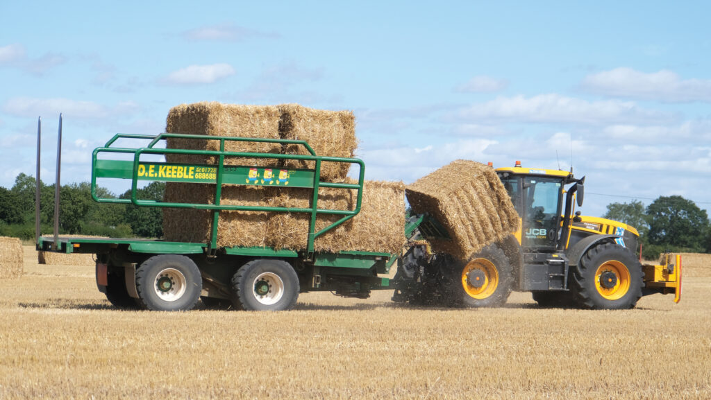 Bale chaser loading bales in a field