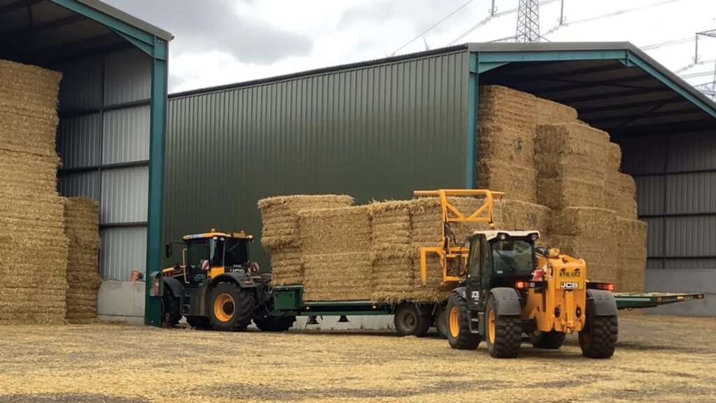 Telehandler moving bales from a trailer