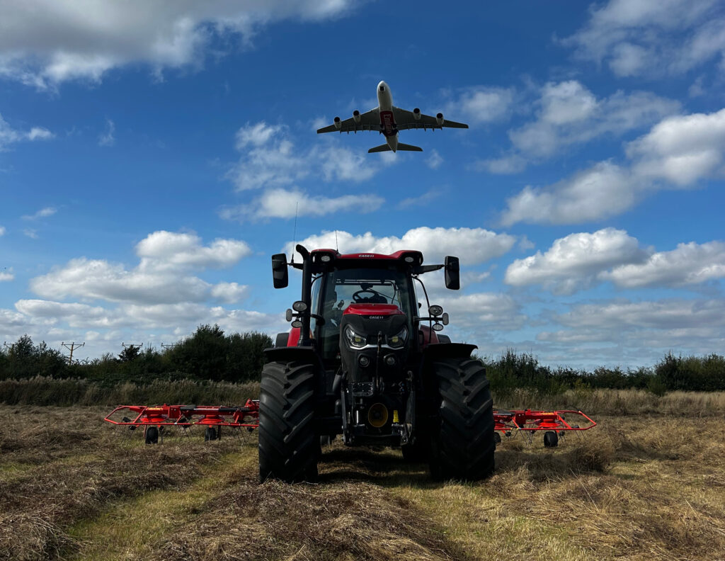 Plane flying over a tractor in a field