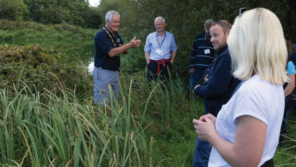 Person showing a group of people reed beds on farm