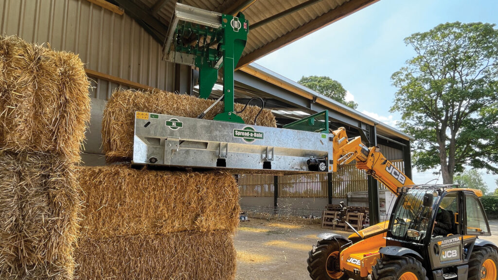 Spread-a-Bale machine lifting bales