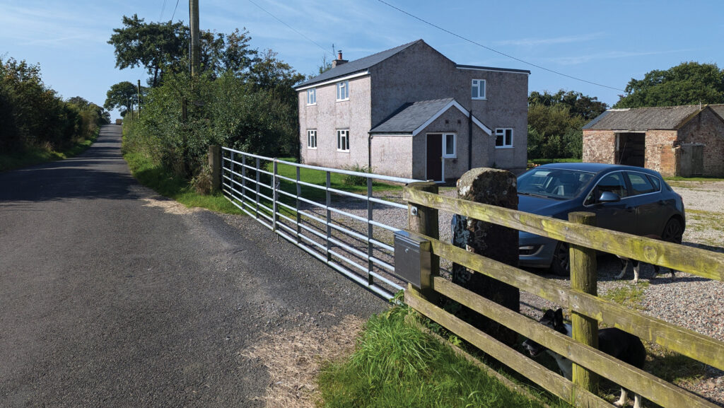 View of house and out building at Thorny Knowe Penton from a roadside