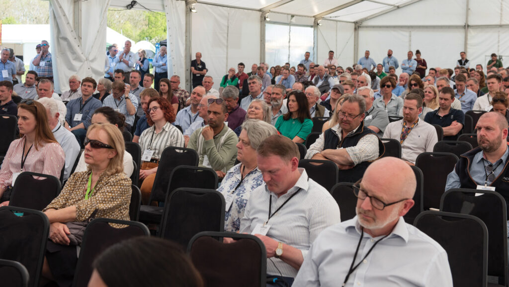 Crowd of people seated in a marquee