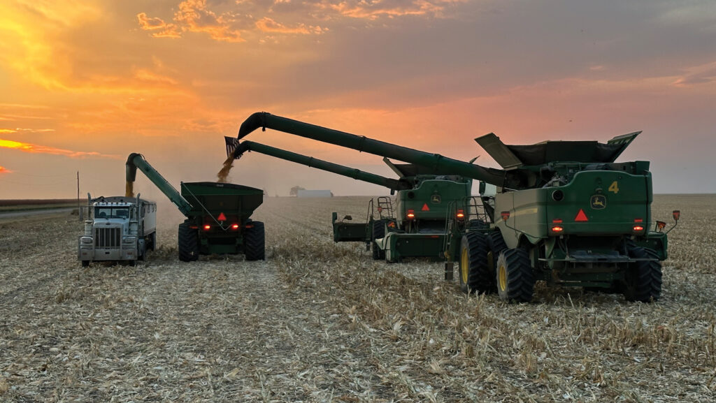 Combines, grain carts and wagons in field