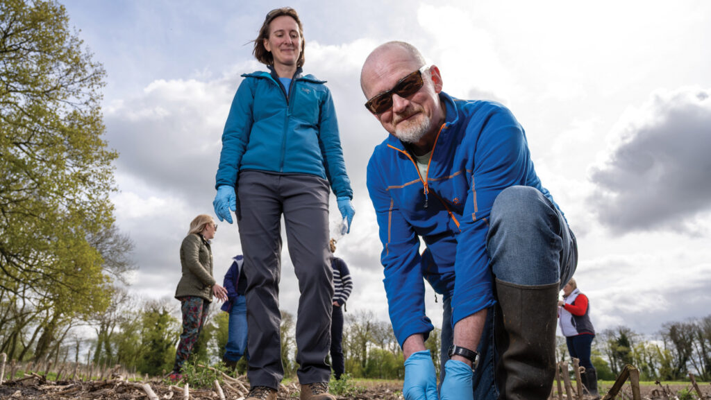 A man and a woman in a field taking soil samples