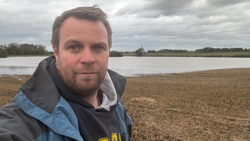 Olly Harrison next to flooded field