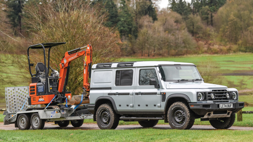 Ineos Grenadier Commercial towing a trailer carrying a digger