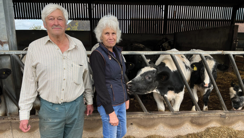 Couple standing in front of cattle shed