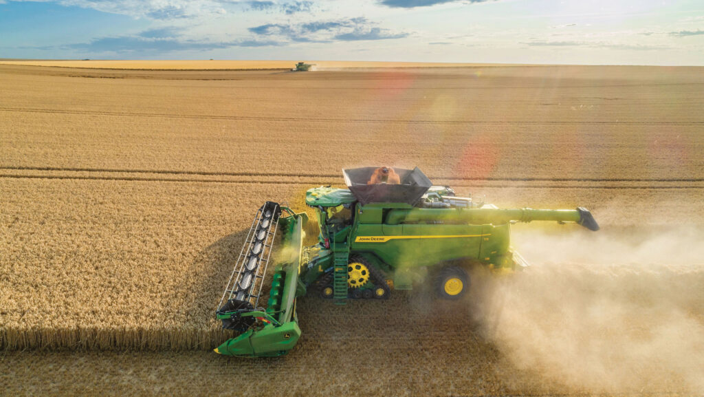 John-Deere T6 800 combine harvester harvesting wheat in a field