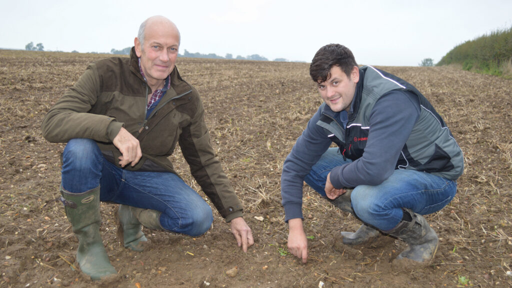 Two men crouching in a field of wheat