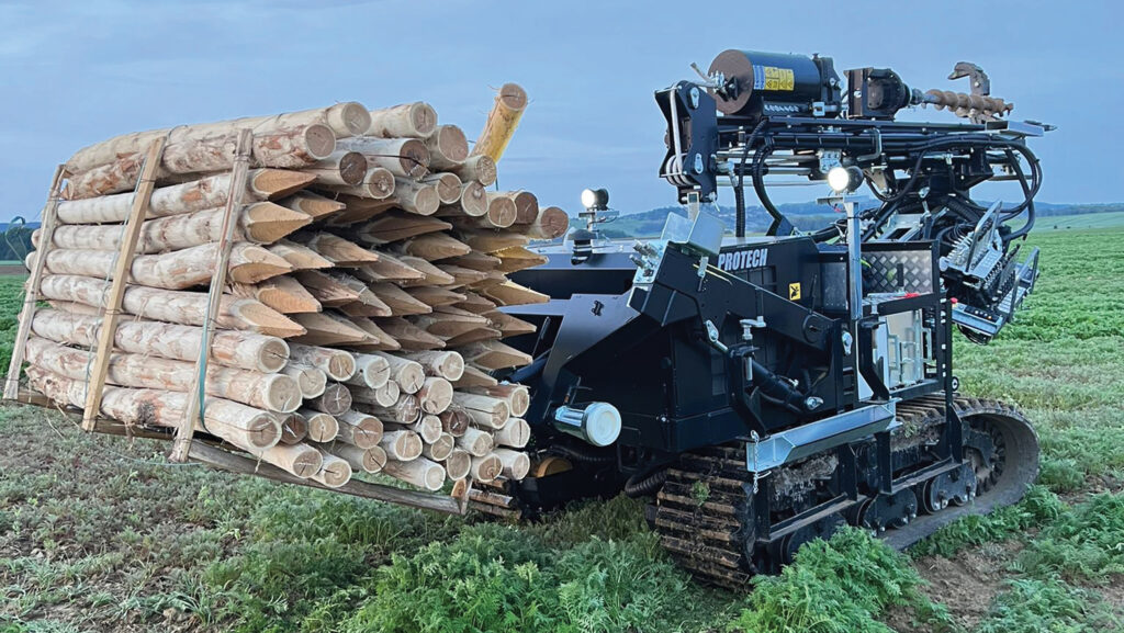 Post hole digger holding a pile of posts