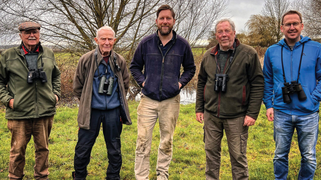 Farmer and birdwatchers in field