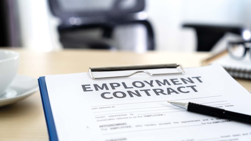 Employment contract and pen on a clip board in an office environment