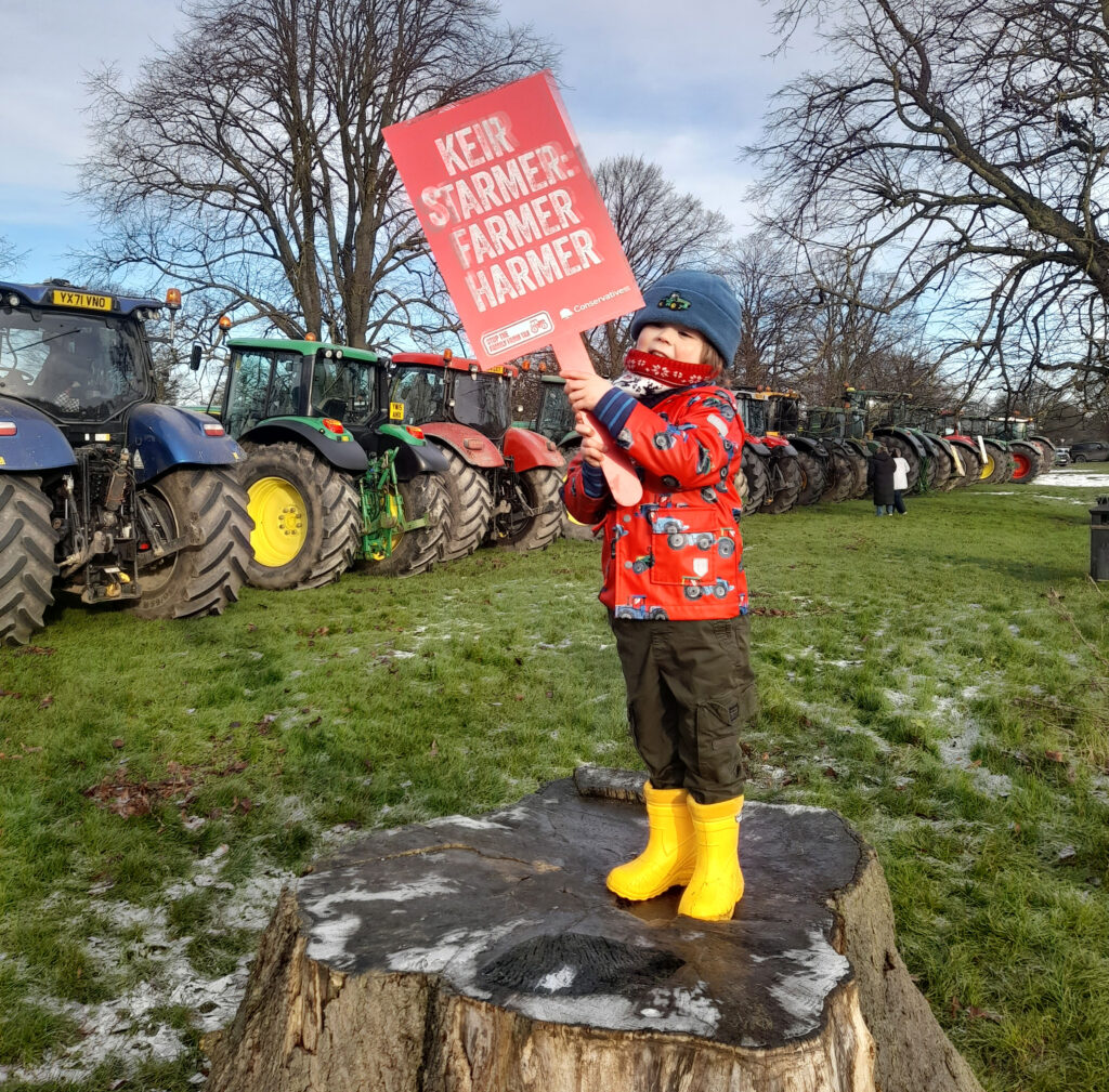 Child holding a placard at a tractor protest