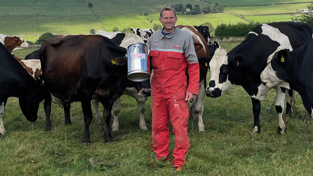 Eddie Andrew standing in a field with cows