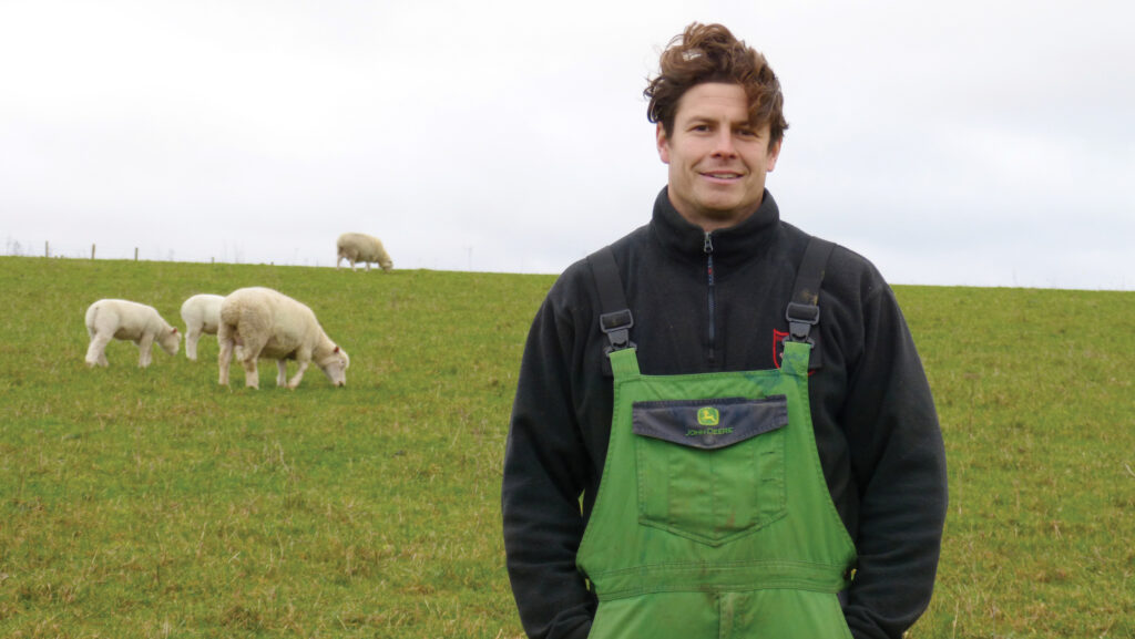 Joe Dufossee in field with sheep