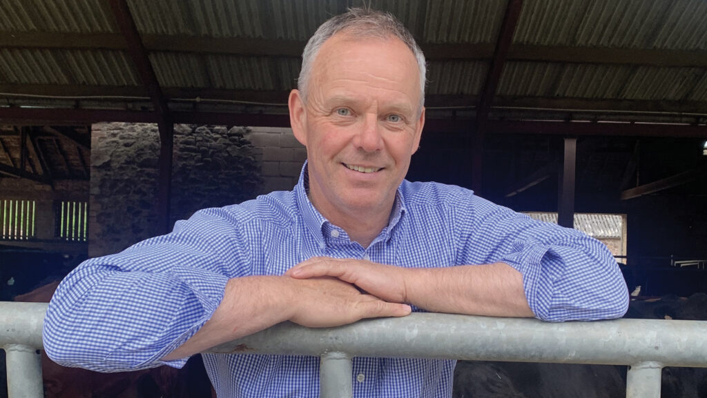 Robert Neill leaning on a farm fence