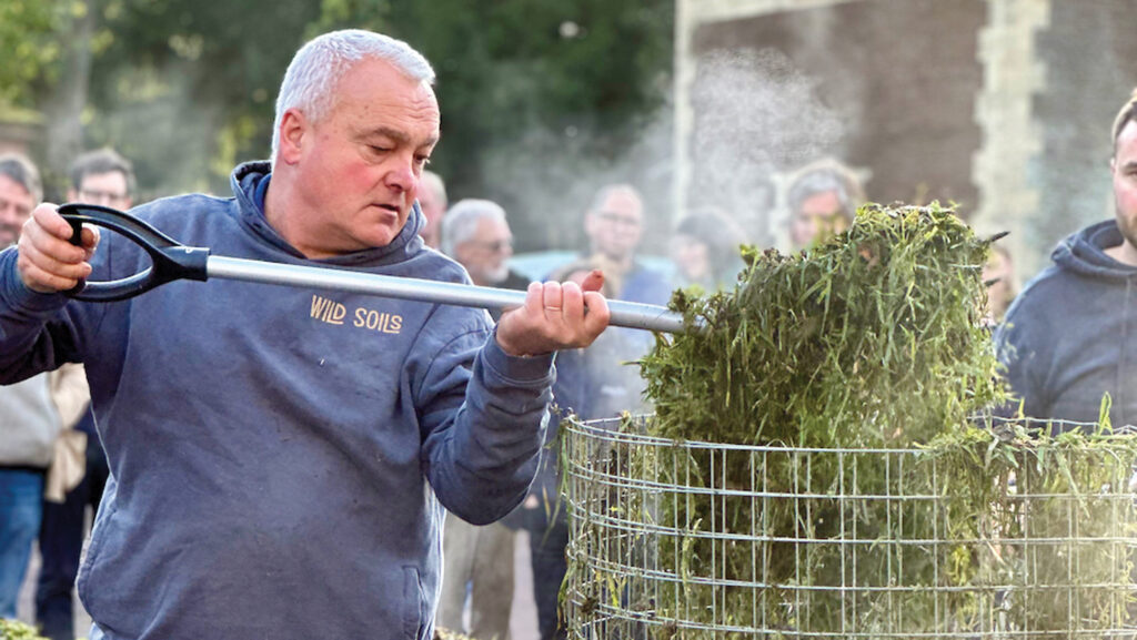 Farmer adding material to a tow composter