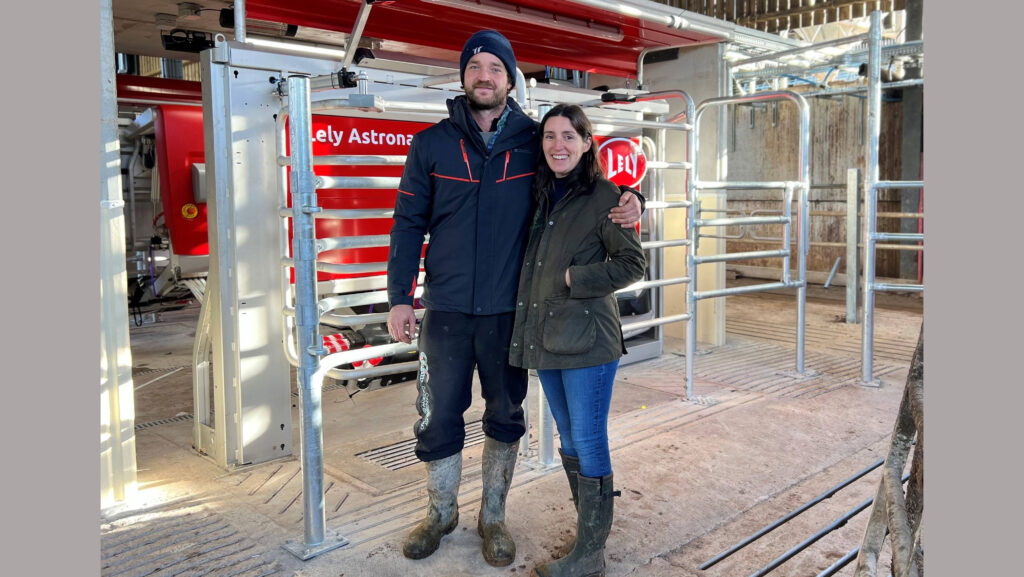 Ben Hembrow standing in front of robot milking machine