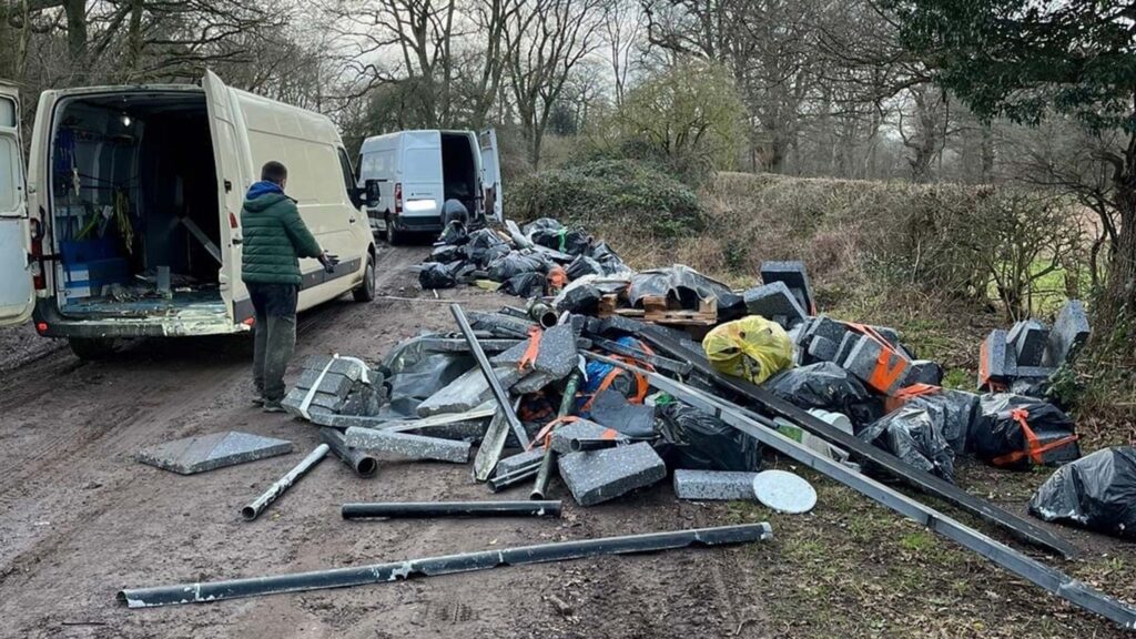 White van with building waste dumped on a country road