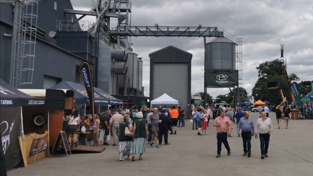 Visitors walking in a farmyard with stalls and farm buildings