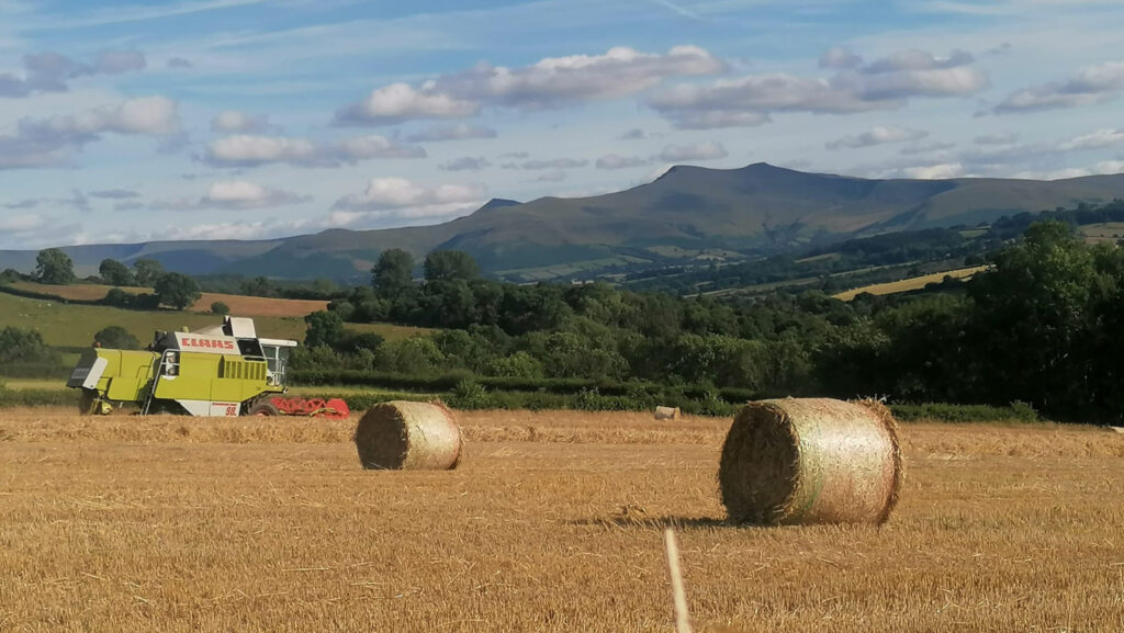 Combine and bales in field in Pontfaen, Brecon