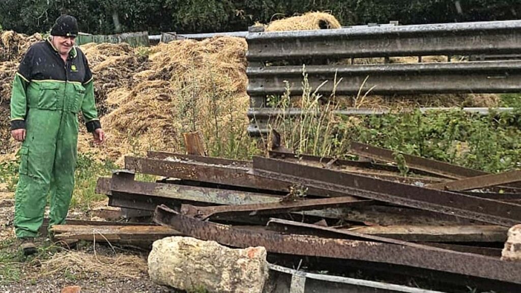 Farmer with pile of steel beams