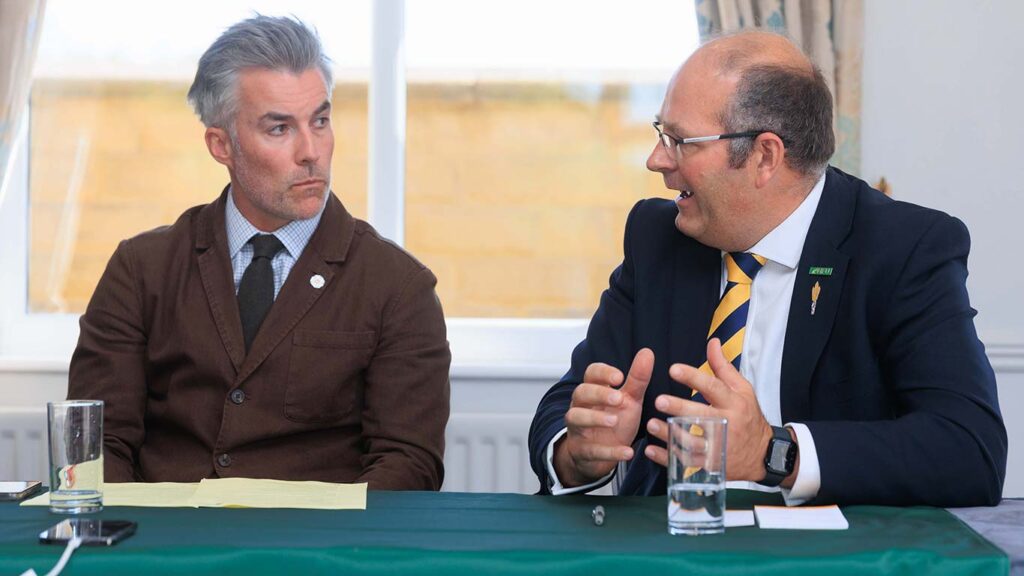 Two men sitting at a conference table talking