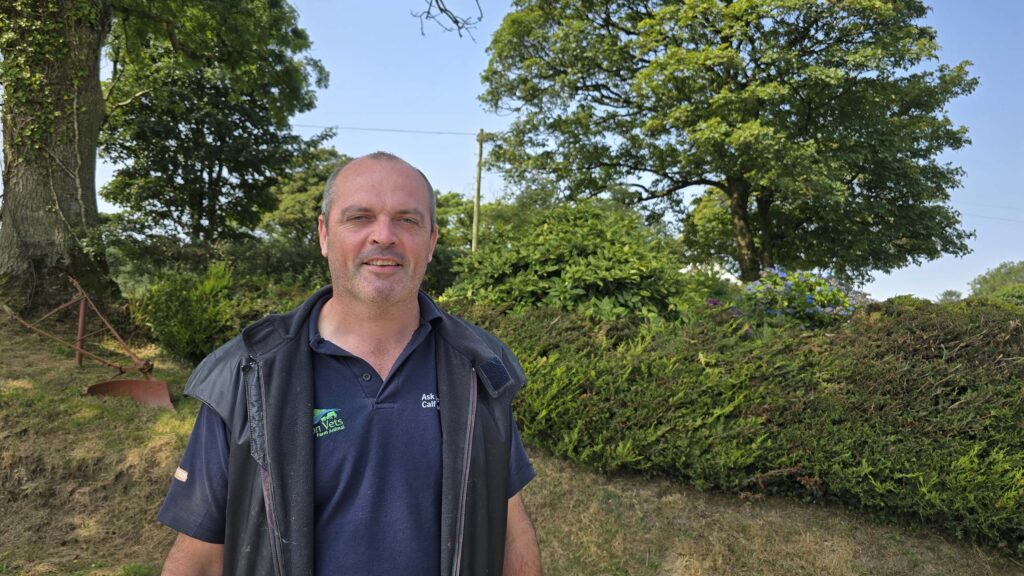 Vet standing in front of a hedge