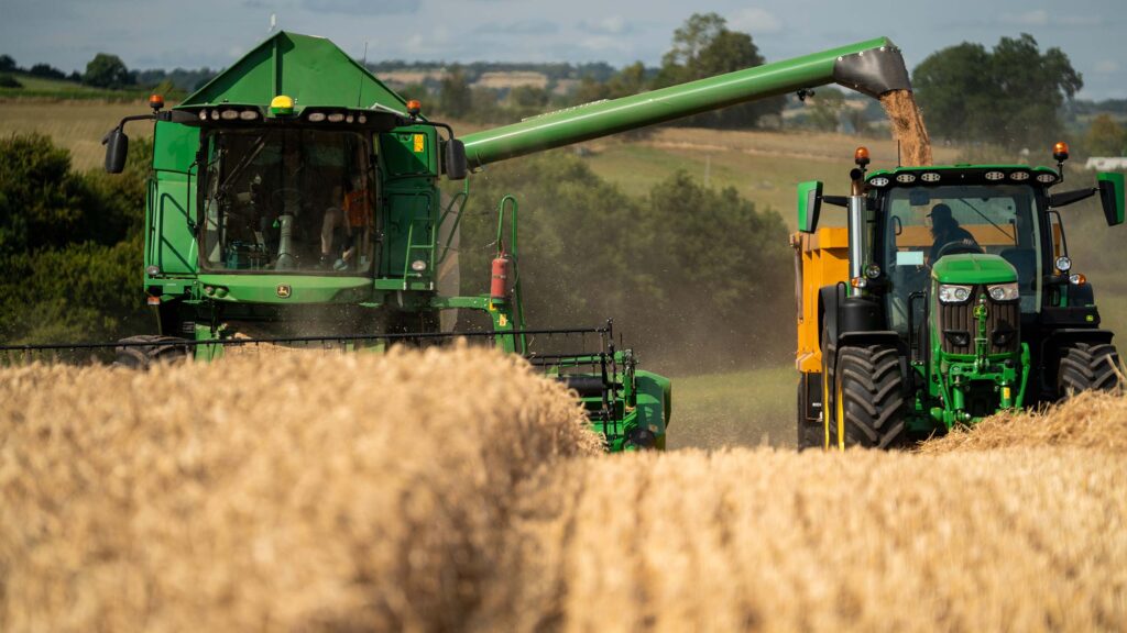Combine and tractor clumbing a hill
