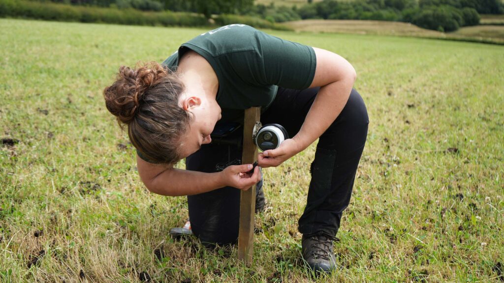 Woman adjusting a camera on a wooden stake
