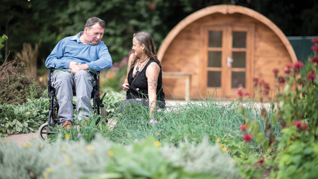 Man in wheelchair with woman in farm garden