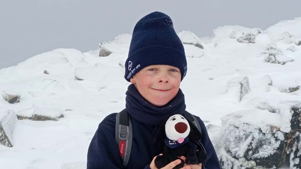 Boy stands on a snowy mountain