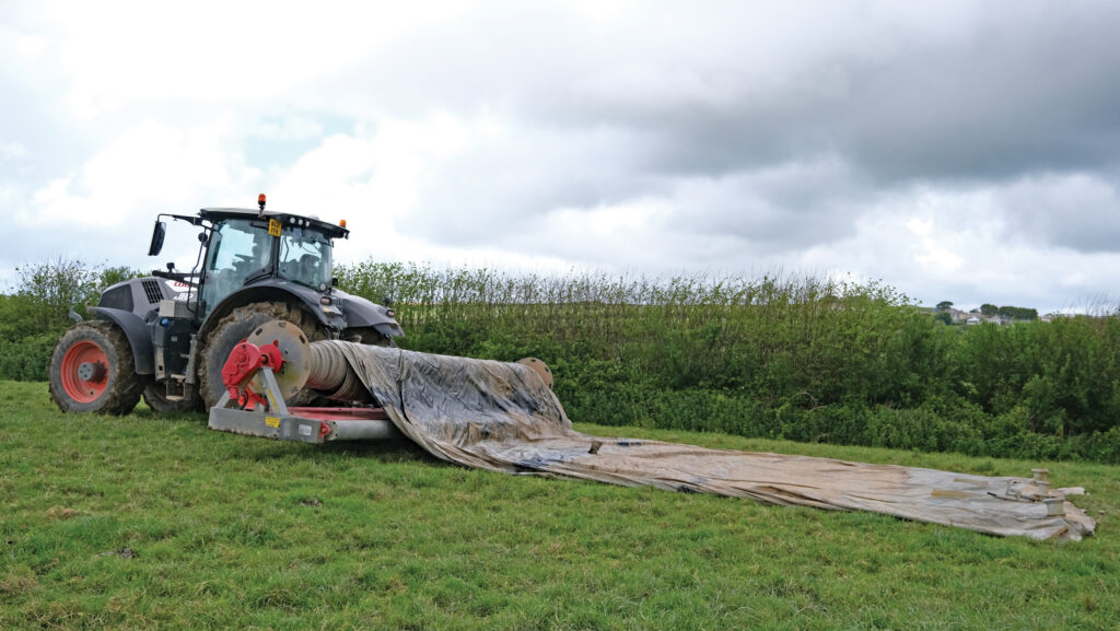 Tractor unrolling a canvas slurry bag