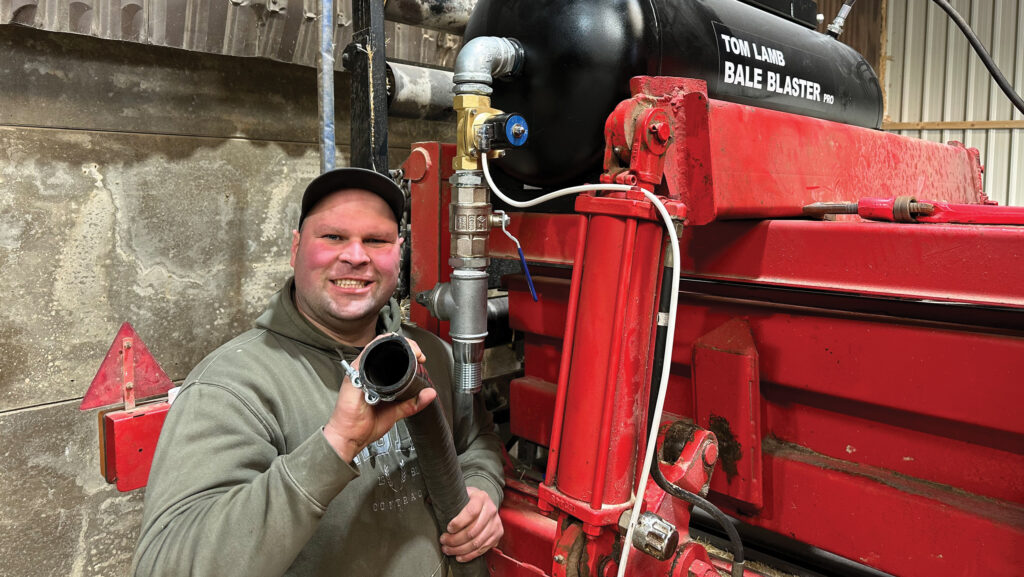 Man stands beside modified baler